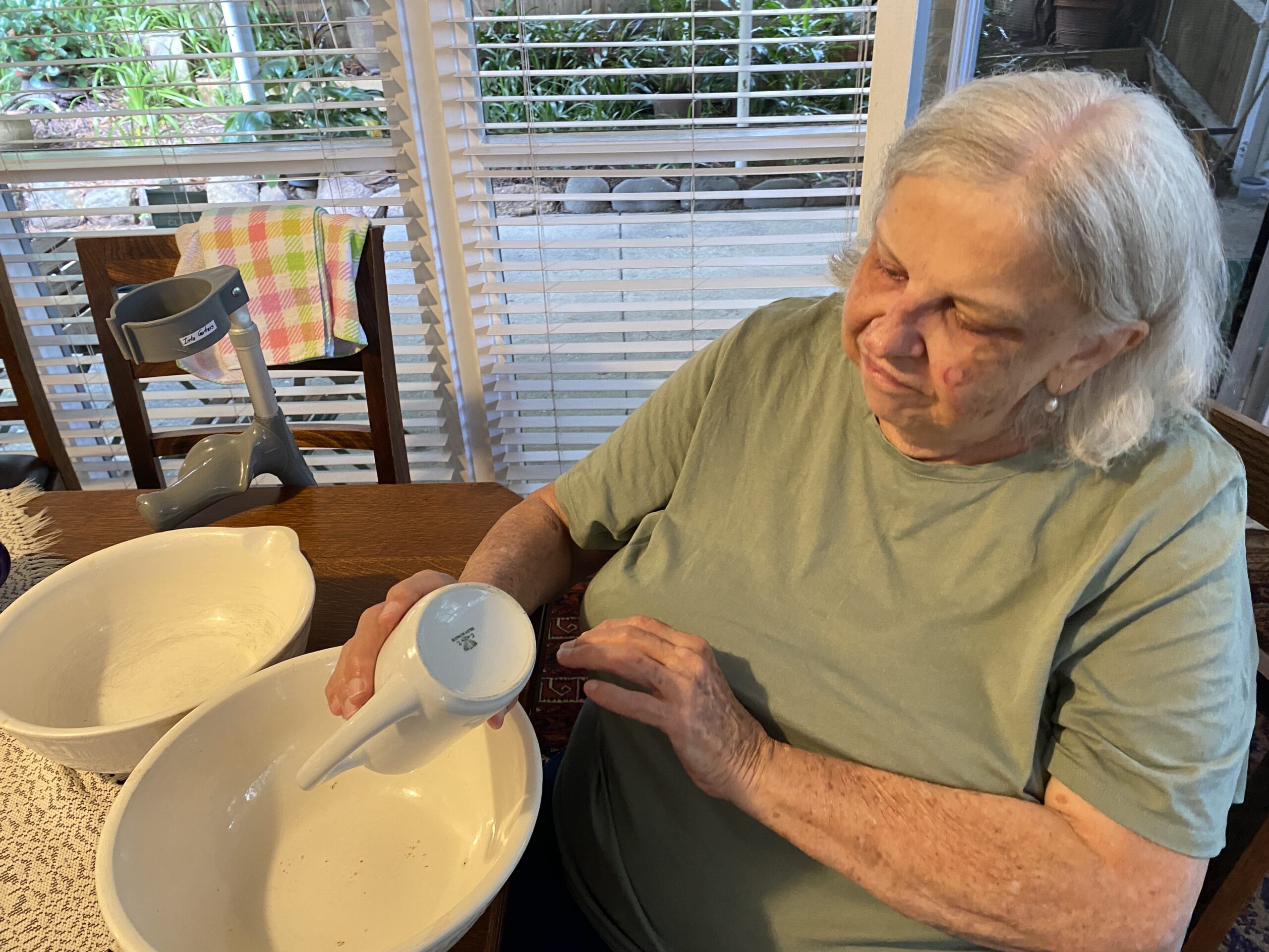 Inta Gertners shows her grandmother Milda Veidis’ bowls for serving rasols to Zigrīda France in Brisbane, Australia, in March 2026. Photo by Inga Česle.